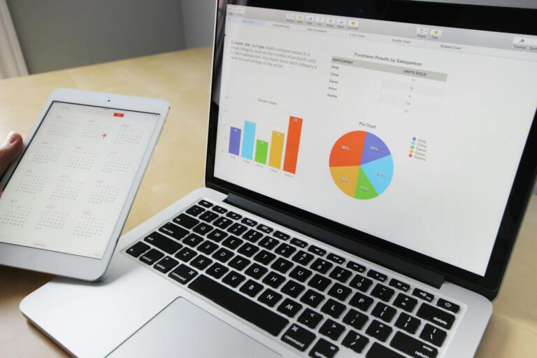 A laptop showing charts beside a planning calendar